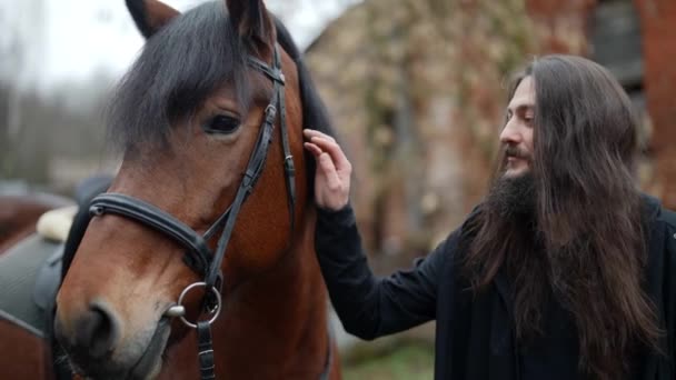 Énigmatique sorcier et son cheval, prise de vue historique dramatique, portrait d'un mystérieux magicien noir — Video