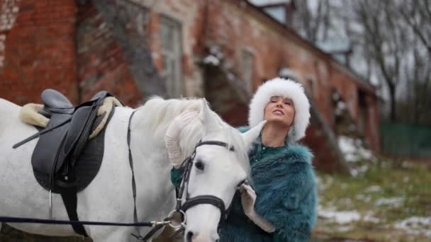 Femme étonnante et cheval blanc à l'extérieur dans la nature, dame embrasse le cheval — Video