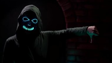 spirit of dead in black hood is showing thumb down and up, symbol of bad and good