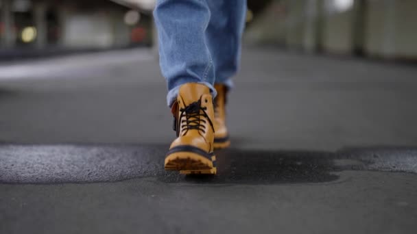 Mujer en zapatos amarillos de moda y pantalones vaqueros azules es caminar plataforma de la estación de tren, primer plano de los pies — Vídeo de stock