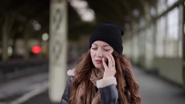 Vrouw belt per telefoon en wacht op iemand in het station, duur en verdrietig gezicht — Stockvideo