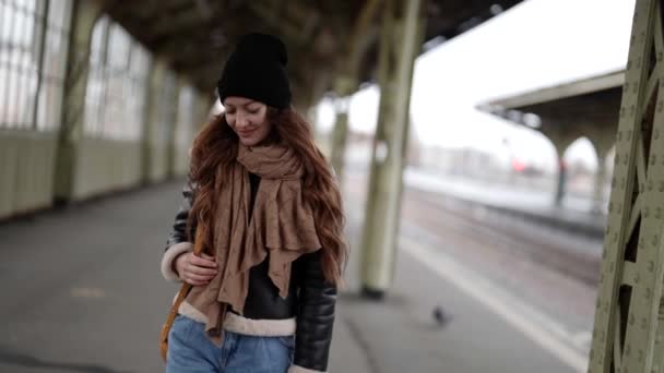 Zorgeloze student vrouw loopt op het perron in de herfst dag, wachttrein — Stockvideo