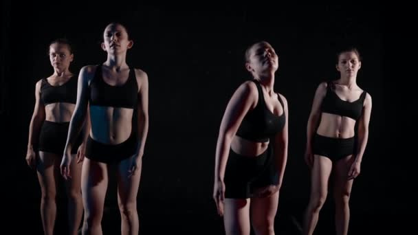 Dançarinas contemporâneas estão dançando em estúdio com paredes pretas, câmera lenta — Vídeo de Stock