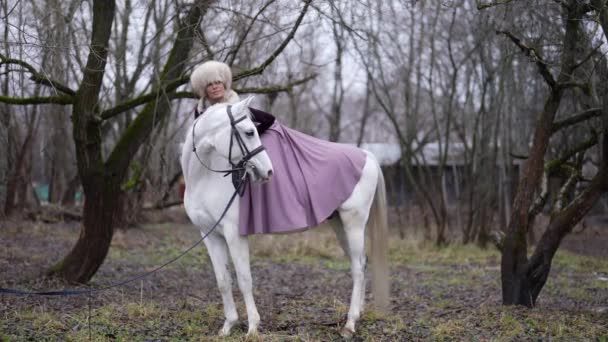 Romantic horse riding in forest in winter, young pretty lady horseback — Stock Video