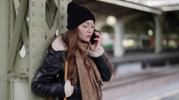 Allein reisende Frau im alten Bahnterminal im Winter, telefoniert mit dem Handy — Stockvideo