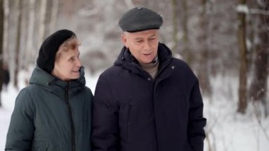 İki emekli kışın ormanda birlikte yürürken, yaşlı adam ve kadın parkta geziniyorlar.