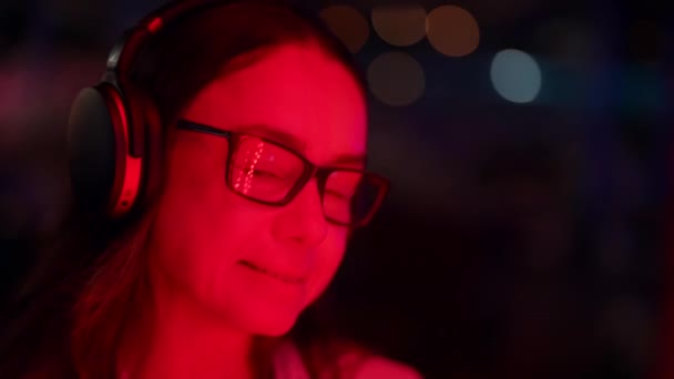 Portret kobiety w średnim wieku ze słuchawkami bezprzewodowymi na głowie, uśmiechnięta pani cieszy się muzyką — Wideo stockowe