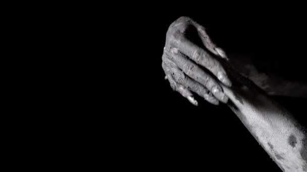 Female hands with long wild and vulturous nails covered by clay, moving in black background — Stock Video