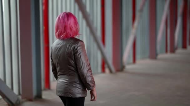 Una adolescente es un erizo solitario en la calle caminando en clima frío. Pelo rosa bebé hipster — Vídeos de Stock