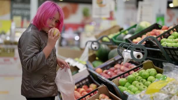 Ένα έφηβο παιδί διαλέγει μήλα στο σούπερ μάρκετ. Ανεξαρτησία για τα παιδιά να κάνουν ψώνια για να βοηθήσουν τους γονείς — Αρχείο Βίντεο