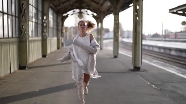 Onnellinen nainen on käynnissä rautatieasemalla ja hymyilee, onnea kokouksen jälkeen pitkä erottaminen — kuvapankkivideo