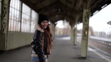 Çekici genç kız sokak tarzı giyiniyor kış mevsimi için banliyö istasyonunda yürüyor