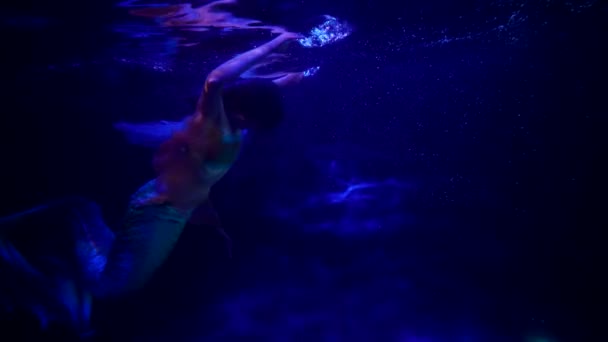 Playful and fascinating mermaid is swimming in depth of sea, dark blue water of ocean or river — Stock Video