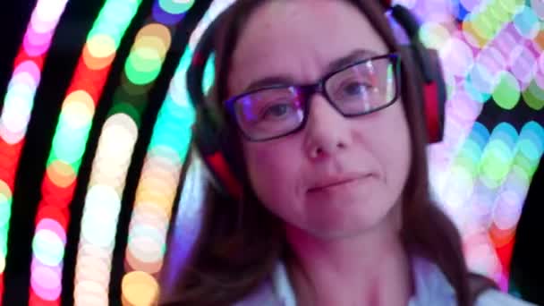Mulher alegre em óculos está usando fones de ouvido sem fio e ouvir música — Vídeo de Stock