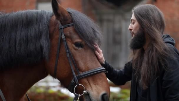 Reiter kommuniziert mit seinem Pferd, gutaussehender und rätselhafter Mann — Stockvideo