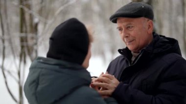 Parkta yaşlı ve mutlu bir çift var. Yaşlı bir adam ve karısı el ele tutuşup birbirlerine bakıyorlar.