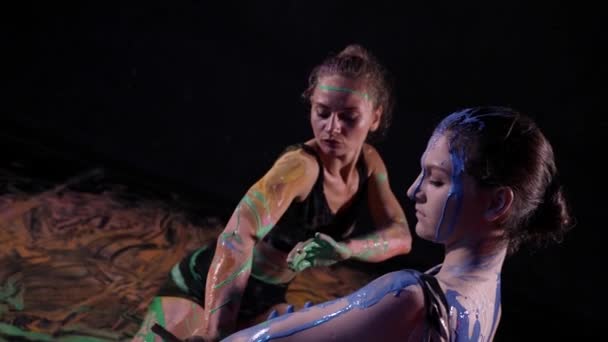 Danza y performance de arte con pinturas, dos mujeres están manchando tintes sobre los cuerpos — Vídeo de stock
