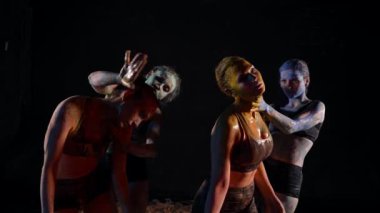 Çağdaş performans, dört genç bayan dansçı vücutlarını karanlığa boyuyor.