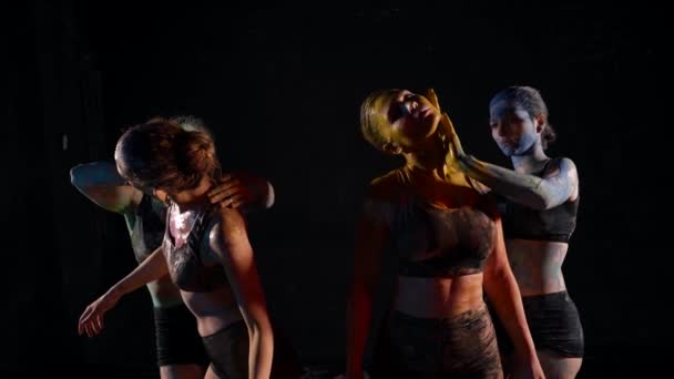 Kreativní taneční skupina, ženy rozmazávají barviva na tělech a tančí ve tmě — Stock video