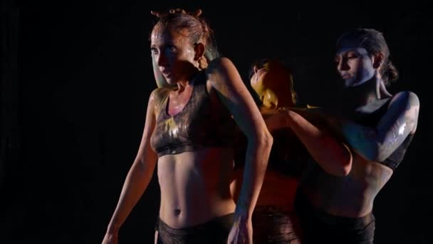 Panie tańczą w ciemności, młode tancerki rozmazują ciała farbami. — Wideo stockowe