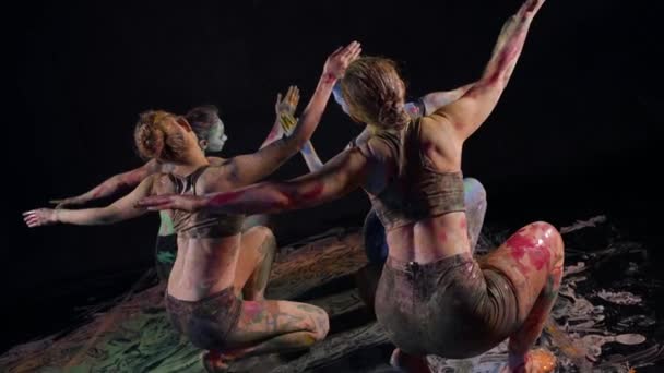 Mujeres manchadas con pinturas están bailando en estudio oscuro, danza contemporánea y performance de arte — Vídeos de Stock