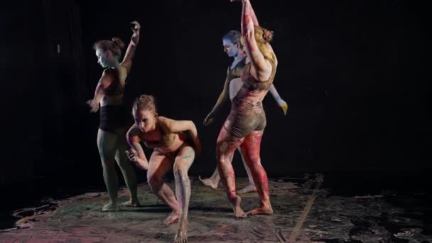 Niesamowity taniec czterech nowoczesnych tancerek, panie są pokryte barwnikami, taniec w ciemności — Wideo stockowe