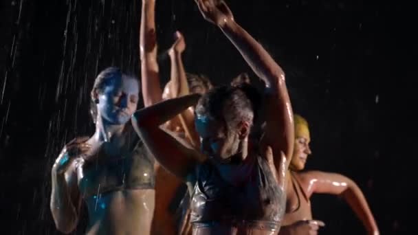 Junge schlanke Frauen sind mit Farbstoffen bedeckt stehen unter der Dusche und tanzen, waschen Farben ab — Stockvideo