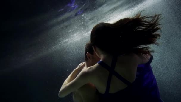 Objetí dvou miláčků pod vodou, muž objímá svou krásnou přítelkyni a víří — Stock video