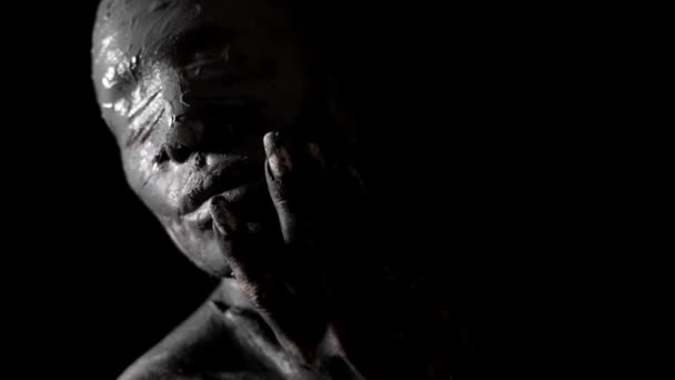 Geblinddoekte vrouw smeert klei op haar huid in duisternis, verschrikking en nachtmerrie schot — Stockvideo