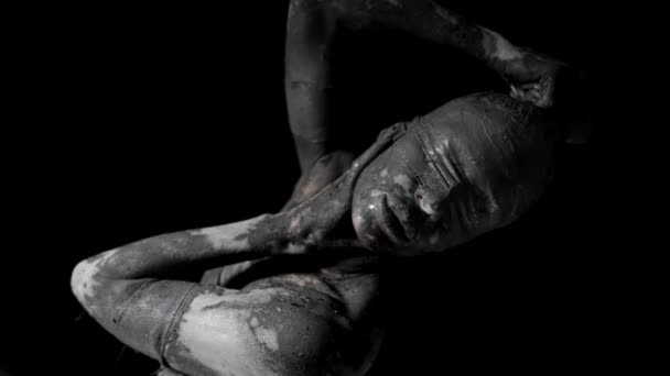Strange woman covered by grey clay and blindfolded in darkness, mysterious life statue — Stock Video