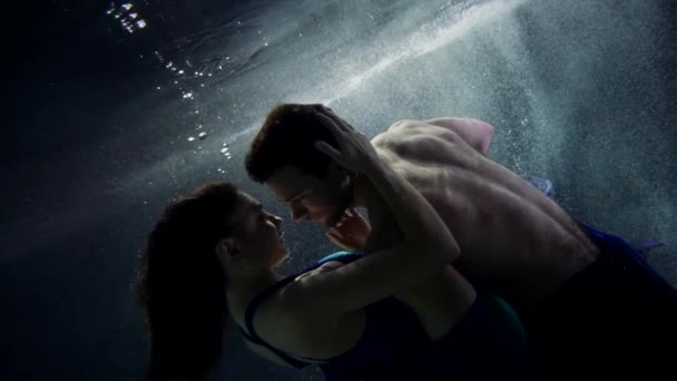 Pria tampan dan wanita cantik merangkul dan berenang di kedalaman kolam renang atau danau — Stok Video