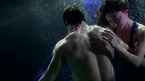 Hezká žena objímá svého přítele pod vodou, milující pár plave ve vodě z moře — Stock video