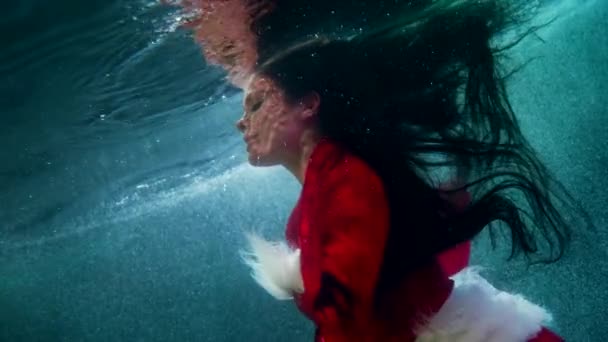 Mulher encantadora está salpicando em água fria sob gelo dentro do rio ou lago, conto de fadas e fantasia — Vídeo de Stock