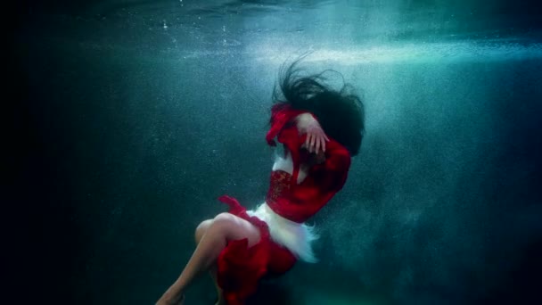 Elegante sexy dama en rojo está nadando bajo el agua, fantástico cuento de hadas de invierno — Vídeo de stock