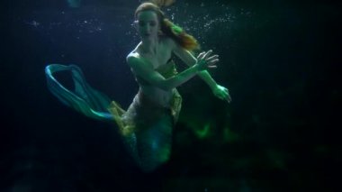 Büyüleyici deniz kızı denizin dibinde yaşıyor, balık kuyruklu bir kadının silueti, peri masalı