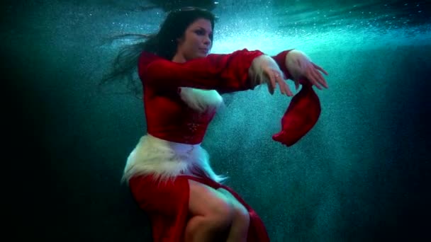 Mujer está nadando en agua fría, tiro bajo el agua con la señora flotante de cuento de hadas de invierno — Vídeos de Stock