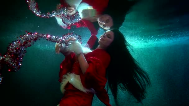 Keajaiban Natal di bawah air, wanita dengan tinsel mengambang di dalam air, tembakan subaquatic — Stok Video