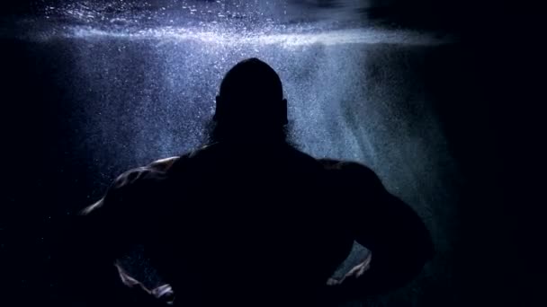 Ciemna sylwetka muskularnego mężczyzny wewnątrz głębi morza lub rzeki, potężna męska postać pod wodą — Wideo stockowe