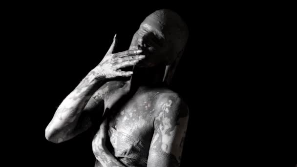 Mysterious naked woman with blindfold and skin covered by clay is moving slowly in darkness — Stock Video