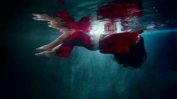 美丽的黑发女子正缓慢地漂浮在神奇的湖水或大海中 水下奇幻镜头 梦境或童话 — 图库视频影像
