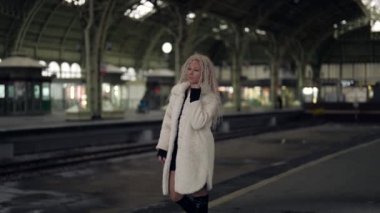 Hüsrana uğramış ve terk edilmiş kadın tren istasyonunda yürüyor, üzgün bir kadının duygusal portresi.