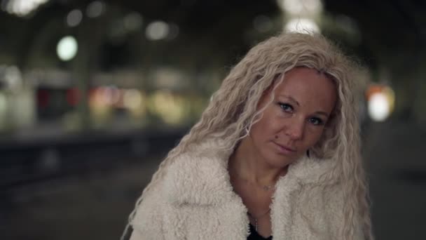 Atemberaubende traurige Dame mit falschen blonden welligen Haaren läuft allein im Bahnhof, Porträt des weiblichen Gesichts — Stockvideo