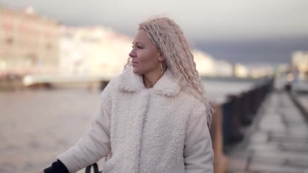 Portret młodej blondynki w nasypie wczesną zimą, urocza kobieta mieszkająca w mieście — Wideo stockowe