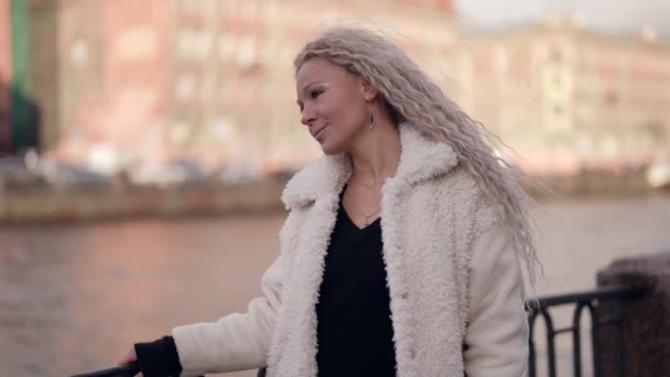 Retrato de mulher no dique da cidade em dia quente de inverno, senhora loira com cabelo estendido — Vídeo de Stock