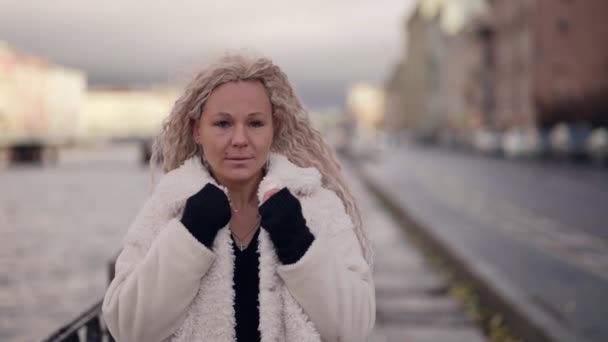 Retrato da bela senhora loira moderna com pestanas falsas e cabelos estendidos na rua no inverno — Vídeo de Stock