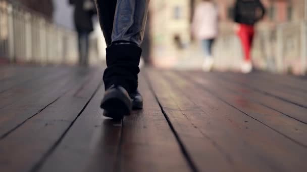 Passant auf Brücke in der Stadt im Herbst oder Winter, Nahaufnahme der Füße, schwarze Damenstiefel — Stockvideo