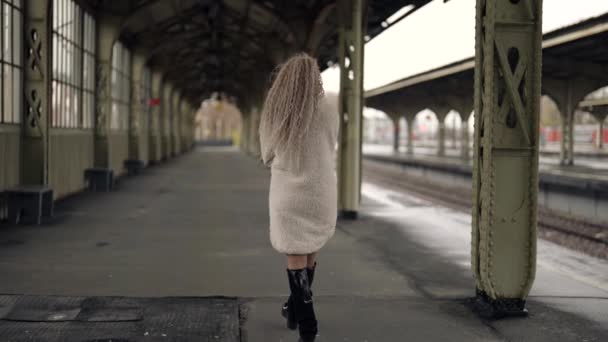 Sexig dam promenerar ensam i gamla tåg terminal på vintern, bakre vyn, trendig kvinna — Stockvideo
