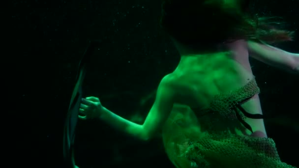 Mooie zeemeermin drijft in donkere diepte van de oceaan, dramatisch en mysterieus groen licht — Stockvideo