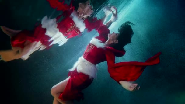 Fantástico tiro subaquático com sexy jovem senhora em vestido vermelho, nadando sob a superfície da água — Vídeo de Stock