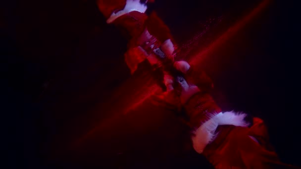 Fantastique prise de vue sous-marine avec belle femme en costume rouge, flottant en profondeur avec lumière rouge — Video